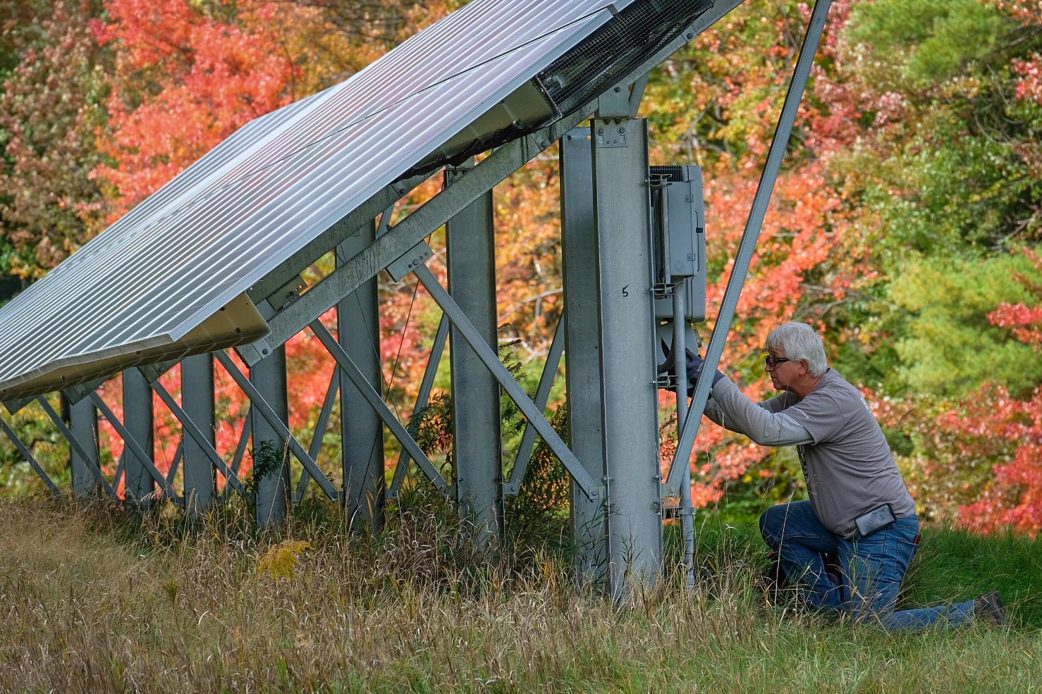 A ReVision technician servicing a ground mount solar array