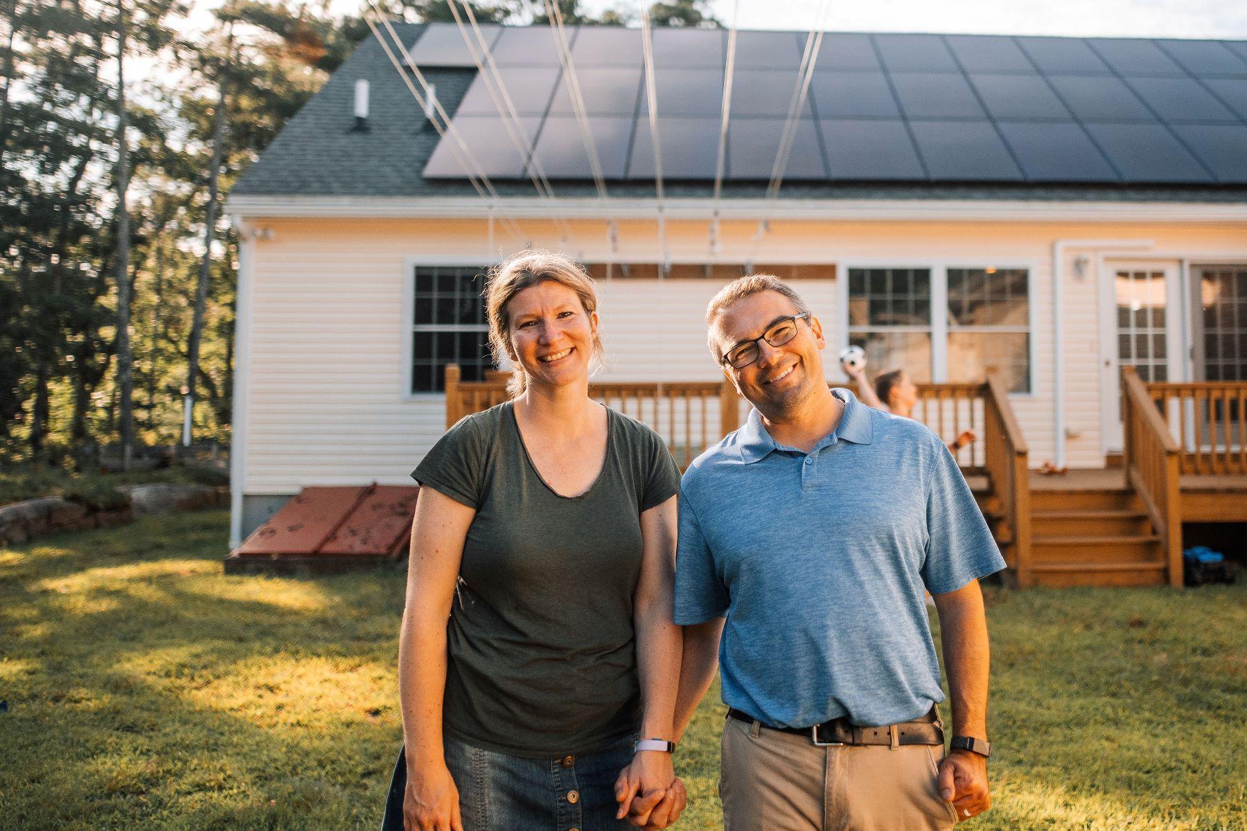 Portrait photo - Couple standing in front of their solar array