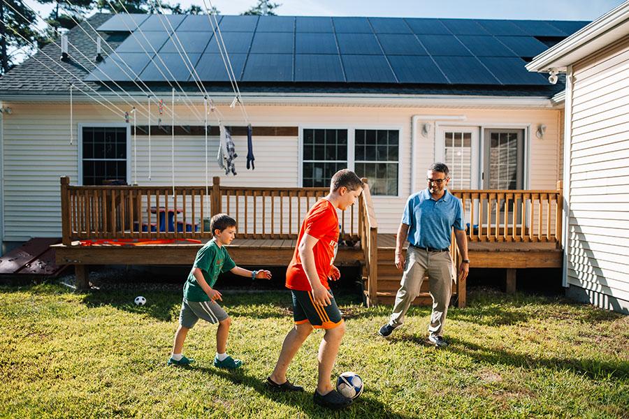 Family playing outside of their solar powered home