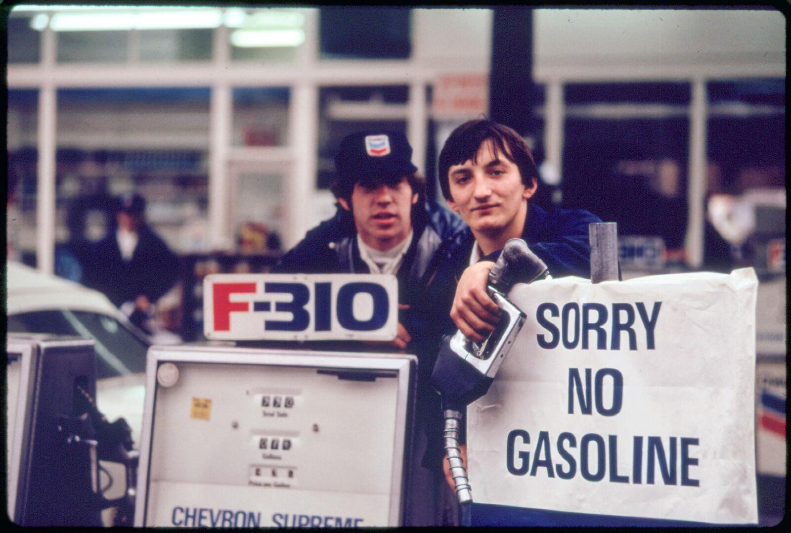Gas Station Attendants Peer Over Their Out Of Gas Sign In Portland NARA